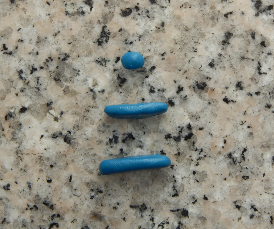 Three pieces of polymer clay: Two rounded rectangular ones and a round one